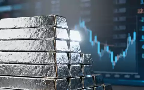 Ein Stapel glänzender Silberbarren, die ein leichtes Licht reflektieren, mit einem unscharfen Hintergrund, der Daten andeutet. - Foto: über boerse-global.de