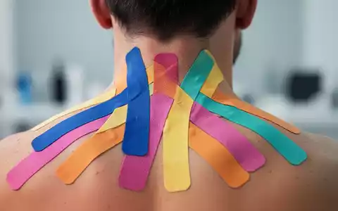 Nahaufnahme des Nackens und oberen Rückens einer Person mit farbigem Kinesiotape in einem therapeutischen Muster. - Foto: über boerse-global.de