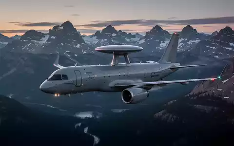 Ein modernes AEW&C-Flugzeug, möglicherweise ein GlobalEye, fliegt bei Sonnenuntergang über eine raue kanadische Landschaft. - Foto: über boerse-global.de