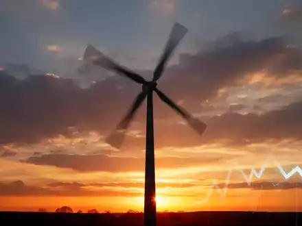 Eine Windkraftanlage bei Sonnenuntergang, mit einem dezenten Pfeil nach unten in der Ecke, der einen leichten Rückgang andeutet. - Foto: über boerse-global.de