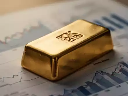 Nahaufnahme eines Goldbarrens mit dem ZKB-Logo, auf einem Finanzdokument mit verschwommenen Diagrammen im Hintergrund. - Foto: über boerse-global.de