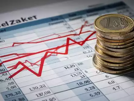 Ein stilisiertes Bild einer Haushalts-Tabelle mit roten Linien, die Kürzungen anzeigen, und einem Stapel deutscher Euro-Münzen. - Foto: über boerse-global.de