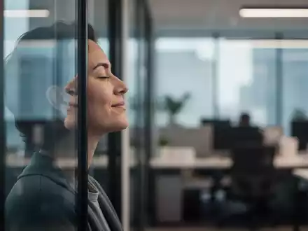 Eine Person macht eine achtsame Pause in einem modernen Büro und blickt entspannt aus dem Fenster. - Foto: über boerse-global.de