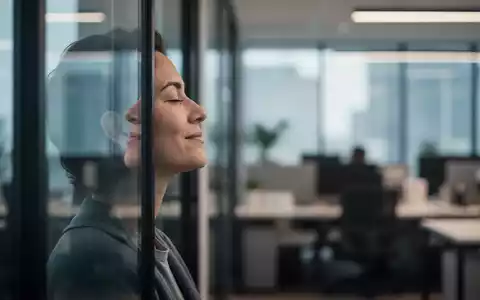 Eine Person macht eine achtsame Pause in einem modernen Büro und blickt entspannt aus dem Fenster. - Foto: über boerse-global.de