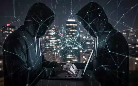 A person in a hoodie types on a laptop, surrounded by glowing digital lines, symbolizing cybercrime and phishing scams. - Foto: über boerse-global.de