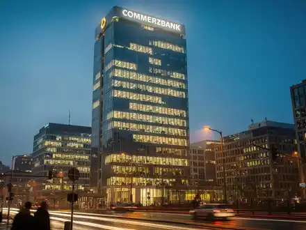 Commerzbank-Zentrale in Frankfurt bei Sonnenuntergang, beleuchtet mit warmen Lichtern. - Foto: über boerse-global.de