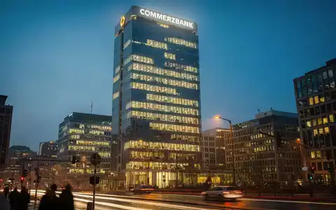 Commerzbank-Zentrale in Frankfurt bei Sonnenuntergang, beleuchtet mit warmen Lichtern. - Foto: über boerse-global.de