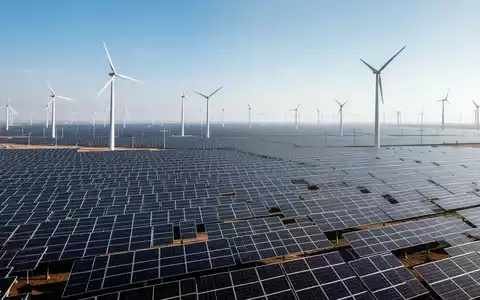 Eine weitläufige Solaranlage und Windturbinen, die das Wachstum erneuerbarer Energien und neue Projekte symbolisieren. - Foto: über boerse-global.de