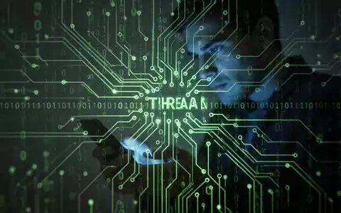 Stylized circuit board with binary code overlay, a blurred person looking at a smartphone in the background. Represents banking trojan threats. - Foto: über boerse-global.de