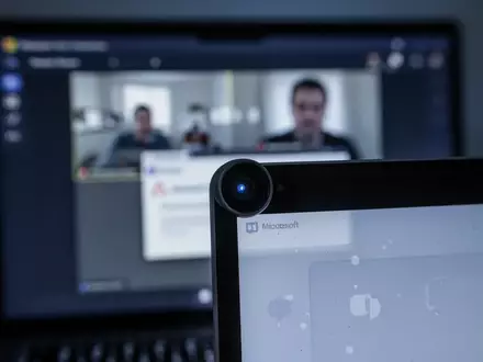 Close-up of a laptop camera lens with a blurred Microsoft Teams screen in the background, showing a technical error. - Foto: über boerse-global.de