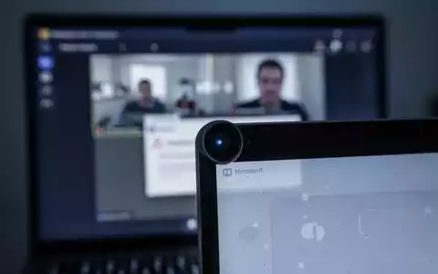Close-up of a laptop camera lens with a blurred Microsoft Teams screen in the background, showing a technical error. - Foto: über boerse-global.de