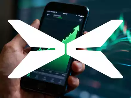 Eine Hand hält ein Smartphone mit einer Aktienmarkt-App, im Hintergrund verschwommene digitale Muster. - Foto: über boerse-global.de