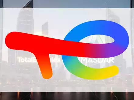 Eine stilisierte Darstellung der Logos von TotalEnergies und Masdar, die ein Joint Venture symbolisieren, vor einem Finanzviertel bei Dämmerung. - Foto: über boerse-global.de