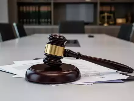 Ein Nahaufnahme eines Holzhammers, der auf juristischen Dokumenten liegt, symbolisiert Gerichtsentscheidungen im Arbeitsrecht. - Foto: ĂŒber boerse-global.de