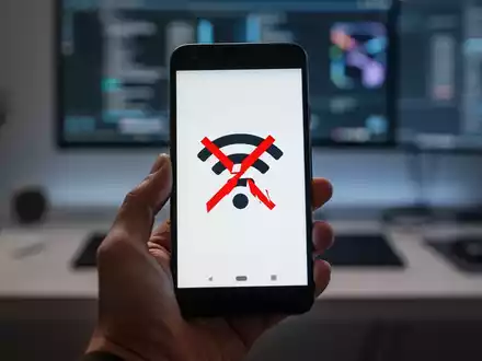 A hand holds a Google Pixel smartphone with a broken Wi-Fi symbol on its screen, set against a blurred tech background. - Foto: über boerse-global.de