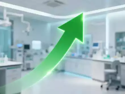 Ein einzelner grüner, nach oben zeigender Pfeil vor dem unscharfen Hintergrund einer modernen Gesundheitseinrichtung. - Foto: über boerse-global.de