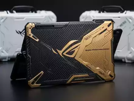 Asus ROG Flow Z13 x Kojima Productions Edition tablet in gold and black with a carbon fiber back panel, next to a white carrying case. - Foto: über boerse-global.de