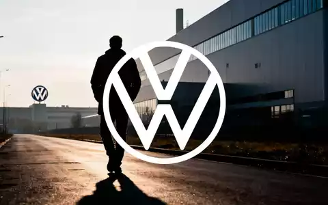 Eine einzelne, silhouettierte Figur geht von einem modernen Fabrikgebäude weg, das auf Arbeitsplatzverluste hinweist. - Foto: über boerse-global.de