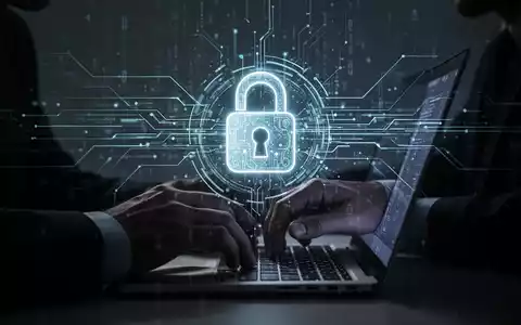 A shadowy figure types on a laptop, with digital lines and a lock icon overlaying the screen, representing cybersecurity threats. - Foto: über boerse-global.de