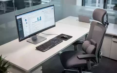 Ein ergonomisch eingerichteter Schreibtisch mit Monitor, Tastatur, Maus und einem modernen BĂŒrostuhl, von oben betrachtet. - Foto: ĂŒber boerse-global.de