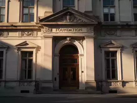 Eine imposante, historische Gebäudefassade, die Stabilität und das Erbe einer Stiftung symbolisiert, bei Sonnenuntergang. - Foto: über boerse-global.de