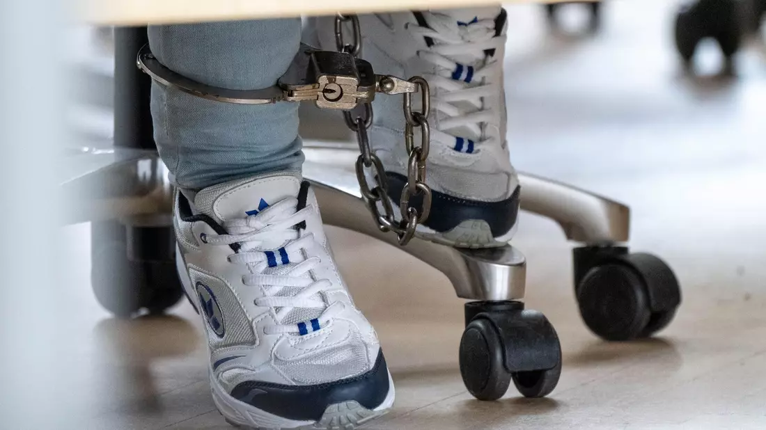 Die Angeklagte wird stets mit Fußfesseln in den Gerichtssaal geführt, die ihr nach Beginn der Verhandlung abgenommen werden. - Bild: Stefan Sauer/dpa