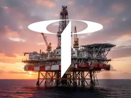 Eine riesige Offshore-Ölbohrplattform mit Bohrturm vor einem dramatischen Sonnenuntergangshimmel, die die Energiebranche darstellt. - Foto: über boerse-global.de