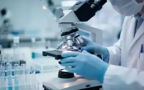 Hände eines Forschers, die ein Mikroskop in einem Labor einstellen, mit Fokus auf pharmazeutische Entwicklung. - Foto: über boerse-global.de