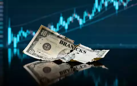 Ein teilweise zerknittertes BRANICKS-Aktienzertifikat liegt auf einer dunklen Oberfläche vor unscharfen, absteigenden Finanzdiagrammen. - Foto: über boerse-global.de