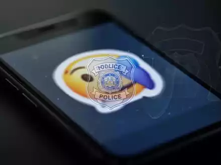 Nahaufnahme eines Smartphone-Bildschirms mit einer verschwommenen digitalen Grafik und einem subtilen Polizeisymbol, das Cyberkriminalität darstellt. - Foto: über boerse-global.de