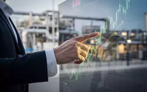 Nahaufnahme einer Hand, die auf einen digitalen Aktienchart mit Aufwärtstrend zeigt, im Hintergrund eine moderne Industrieanlage. - Foto: über boerse-global.de