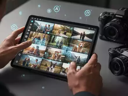 Hände eines Fotografen, die ein Tablet mit einer Bildauswahl in Lightroom Classic bedienen, umgeben von Fotoausrüstung. - Foto: über boerse-global.de