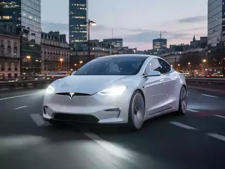 A sleek white autonomous electric car, resembling a Tesla, drives on a highway through a modern European city at dusk. - Foto: über boerse-global.de