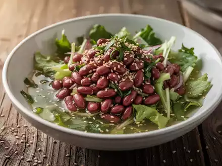 Eine Nahaufnahme einer gesunden Salatschüssel mit roten Bohnen, Sesamsamen und einer Essigdressing auf einem Holztisch. - Foto: über boerse-global.de