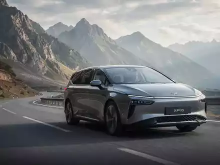 Ein futuristischer XPeng X9 Elektro-MPV fährt auf einer Bergstraße mit malerischer Landschaft im Hintergrund. - Foto: über boerse-global.de
