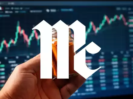 Eine Hand hält ein Gewürzglas vor einem verschwommenen Hintergrund mit Finanzdaten, symbolisch für McCormick's Quartalszahlen. - Foto: über boerse-global.de