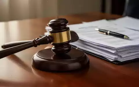Ein Gavel auf einem Holztisch, umgeben von Gesetzbüchern und Dokumenten, symbolisiert Arbeitsrecht und Gerichtsurteile. - Foto: über boerse-global.de