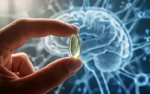 Eine Hand hält eine Fischölkapsel vor einem verschwommenen Hintergrund aus abstrakten neuronalen Mustern, die kognitive Gesundheit symbolisieren. - Foto: über boerse-global.de