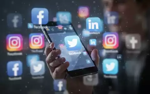 Eine junge Person hält ein Smartphone; im unscharfen Hintergrund sind mehrere Social-Media-App-Symbole zu sehen. - Foto: über boerse-global.de