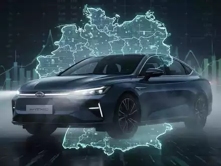Ein modernes BYD Plug-in-Hybridauto vor einer stilisierten Deutschlandkarte mit digitalen Finanzdaten im Hintergrund. - Foto: über boerse-global.de