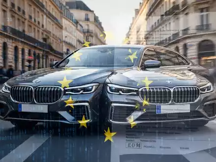 Ein modernes deutsches Luxusauto, teilweise verdeckt von abstrakten EU-Regulierungsdokumenten, auf einer verschwommenen europäischen Stadtstraße. - Foto: über boerse-global.de