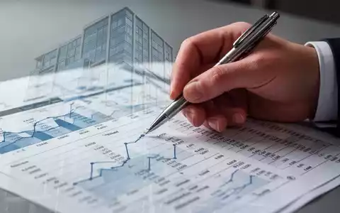 Nahaufnahme einer Hand, die mit einem Stift auf ein Finanzdokument zeigt, mit einer subtilen Überlagerung eines modernen Gebäudes. - Foto: über boerse-global.de