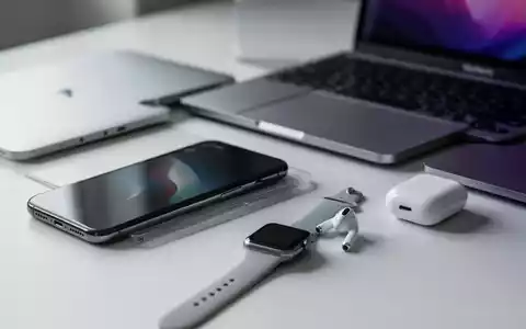 A collection of Apple devices, including an iPhone, MacBook, Apple Watch, and AirPods, displayed on a clean surface. - Foto: über boerse-global.de