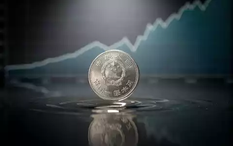 Eine einzelne chinesische Yuan-Münze fällt auf eine dunkle, spiegelnde Oberfläche, mit einem unscharfen Diagramm im Hintergrund. - Foto: über boerse-global.de