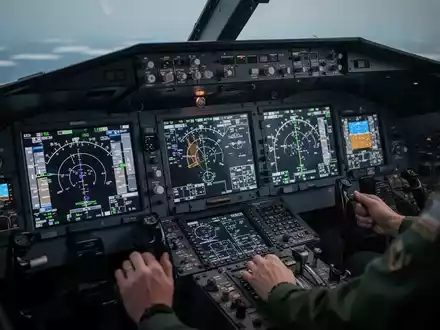 Nahaufnahme eines modernen Flugzeugcockpits mit Bildschirmen und Bedienelementen, die Präzision und Spitzentechnologie betonen. - Foto: über boerse-global.de