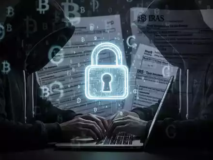 A person in a hoodie types on a laptop, with digital padlock and cryptocurrency symbols, representing crypto scams and fraud. - Foto: über boerse-global.de