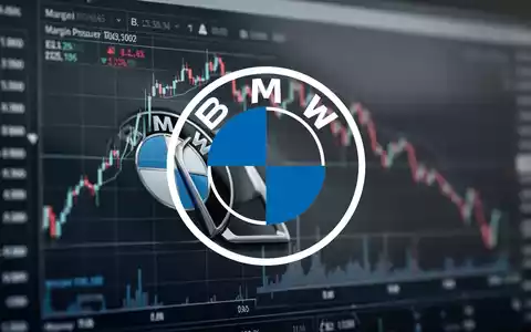 Ein unscharfes BMW-Logo vor einem Finanzdiagramm mit Abwärtstrend, das gesenkte Margenziele symbolisiert. - Foto: über boerse-global.de