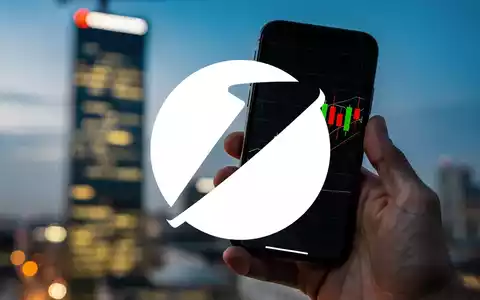 Eine Hand hält ein Smartphone mit Börsenkursen, im Hintergrund verschwommen der Commerzbank-Turm. - Foto: über boerse-global.de