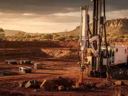 Eine professionelle Fotografie einer australischen Bergbaulandschaft mit einem Bohrer und weitem Outback unter dramatischem Himmel. - Foto: über boerse-global.de