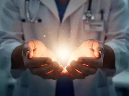 Hände halten sanft ein leuchtendes, ätherisches Licht, das ganzheitliche Heilung und Wohlbefinden symbolisiert. - Foto: über boerse-global.de